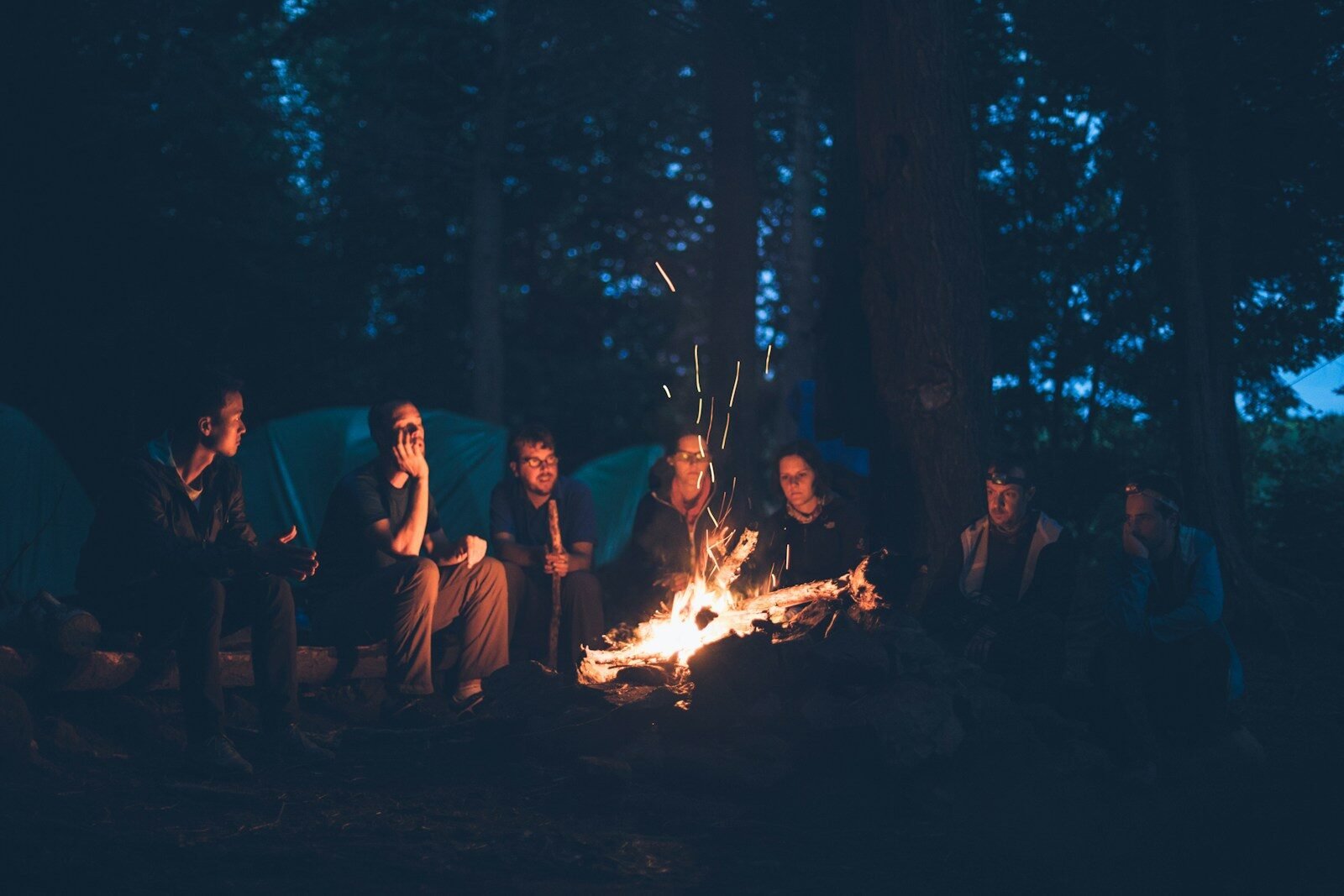 People sitting around a bonfire at night